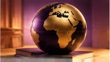 A deep purple globe with its continents in gold, Africa facing forward, resting on books in a purple-lit room