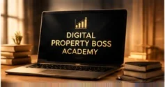 An open laptop on a desk showing the Digital Property Boss Academy mark, between stacks of books