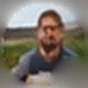 The portrait on Mary Mark’s comment: a bearded man in a dark T-shirt, outdoors on grass