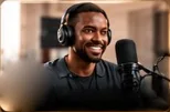 A smiling podcaster in headphones at a studio microphone