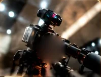 A camera rig on a tripod in a dim studio, lights out of focus behind it